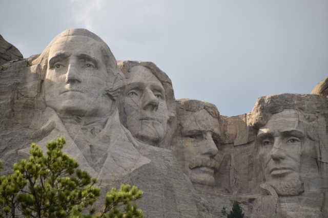 4人の大統領の彫像（アメリカ合衆国・サウスダコタ州）。ラシュモア山国立記念公園に顔を彫られているのは左からJ・ワシントン、T・ジェファーソン、T・ルーズベルト、A・リンカーン各大統領。リンカーンは肖像が使われた最初の人物（5ドル紙幣、1セントコイン）。