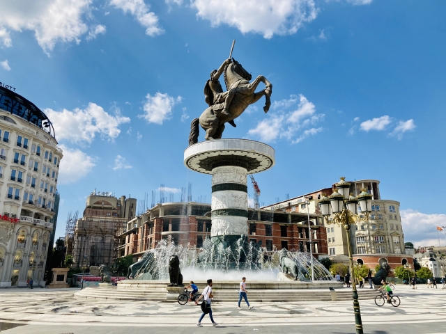 アレクサンドロス大王の銅像（北マケドニア・スコピエ）。首都・スコピエ新市街の中心部にある「マケドニア広場」に立つ。台座をあわせると、高さ約25mという巨大な銅像で、足元には8頭のライオンがいる。マケドニア観光の拠点であり、撮影スポットだ。