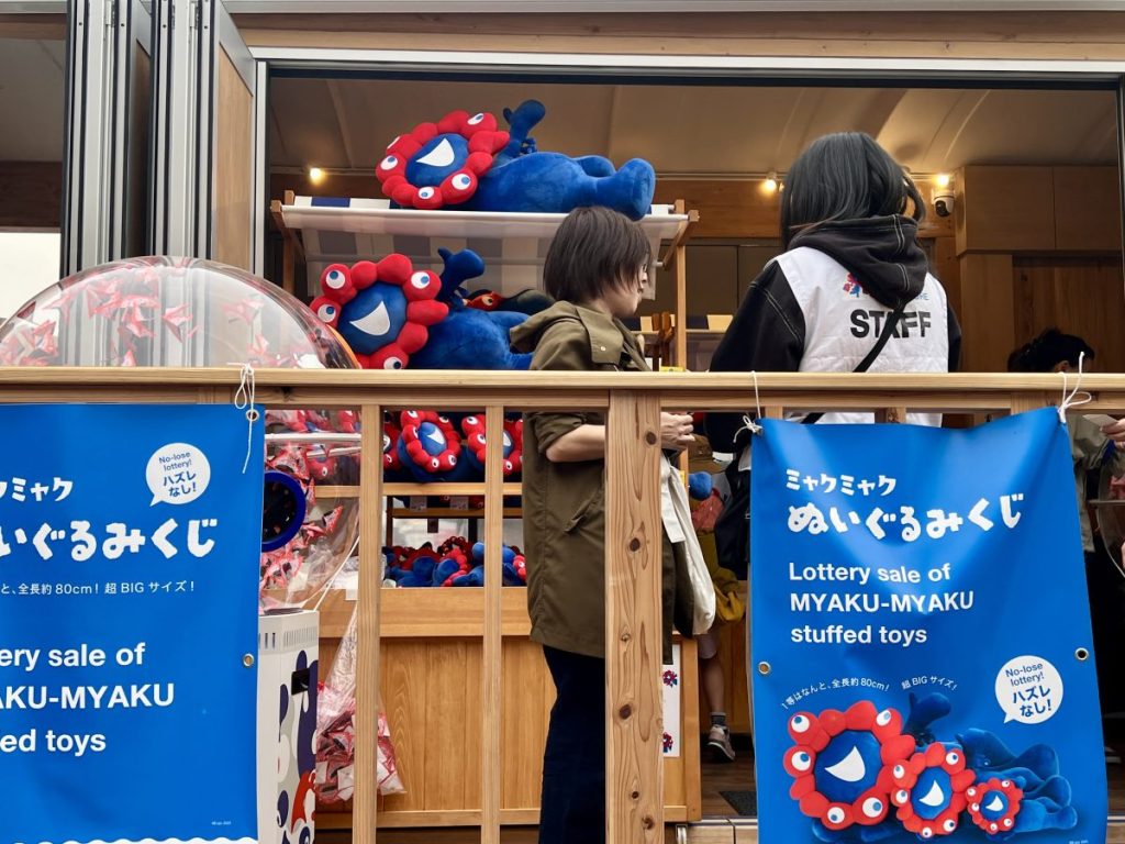 「ミャクミャクぬいぐるみくじ」の寝そべりミャクミャク。