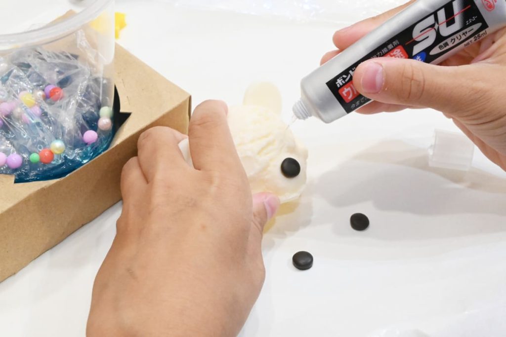 接着剤を使ってくまの目を取り付けます