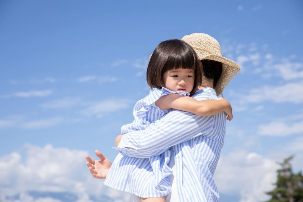 子どもを抱っこする親