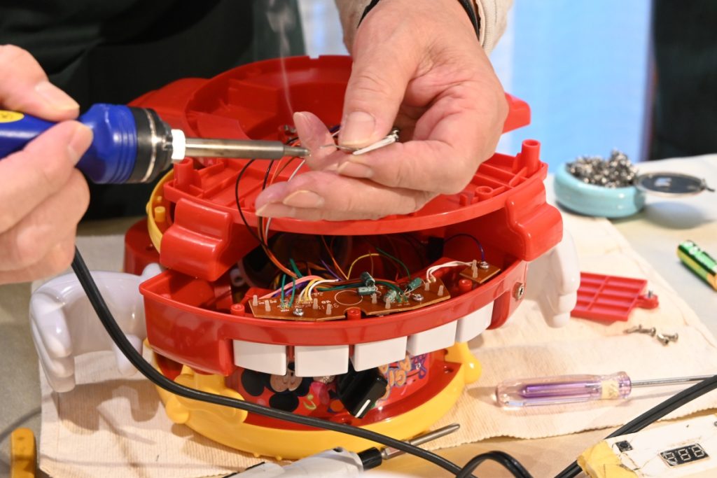 おもちゃを分解し、中の配線を繋ぐ様子