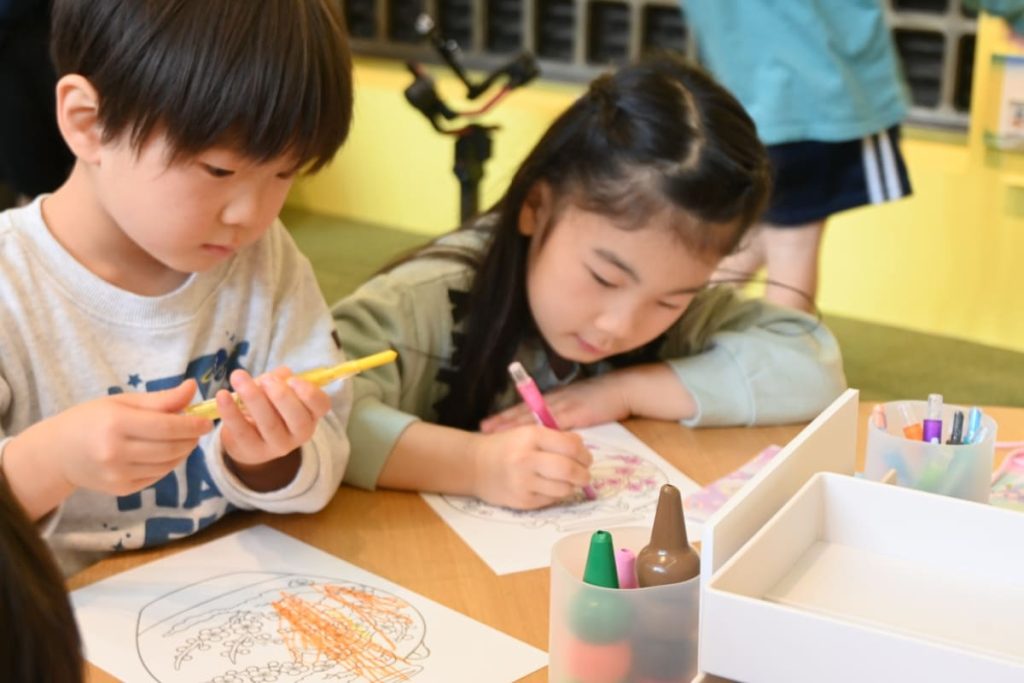 好きな色を選びながら、真剣な表情でぬりえに取り組む子ども